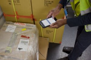 Delivery driver scanning a package for shipment tracking update